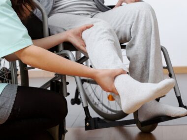 wearable device | SMA News Today | Aids | Person helping to raise leg of patient in wheelchair