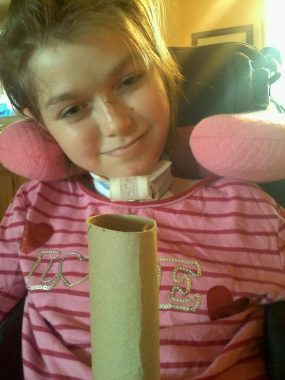 swallowing issues | SMA News Today | photograph of Halsey with her trach, staring at a ladybug on a cardboard tube 