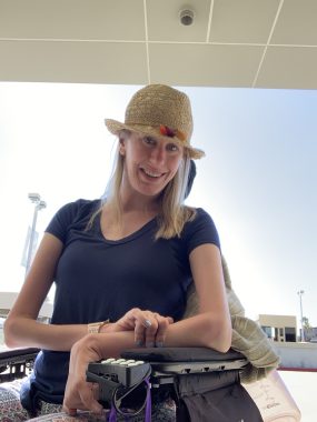 waiting for diagnosis | SMA News Today | Jessica Keogh sits in her chair outdoors, smiling and wearing a pretty hat