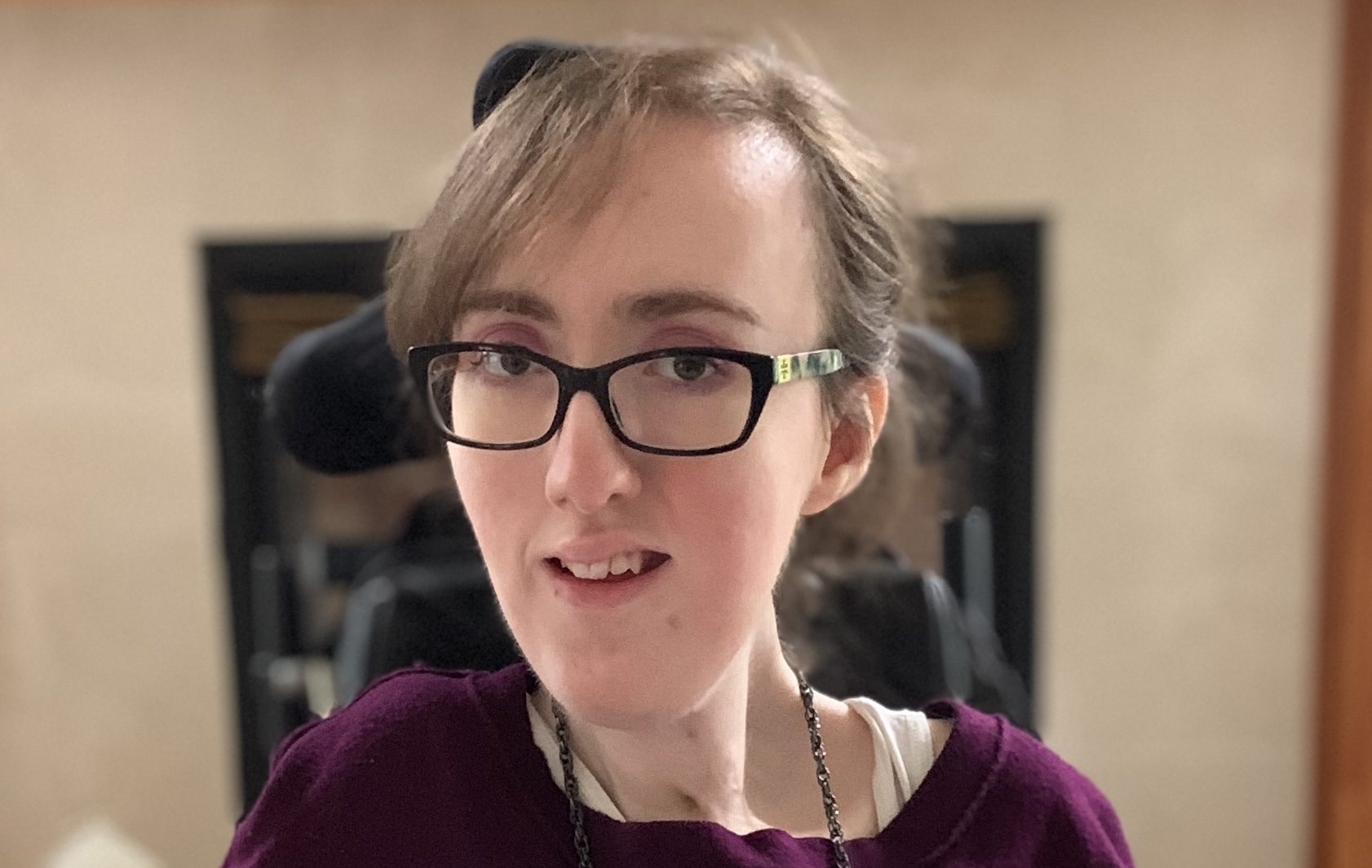 A close-up head shot of a woman with glasses.