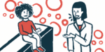 A doctor speaks to a child seated on a bench.