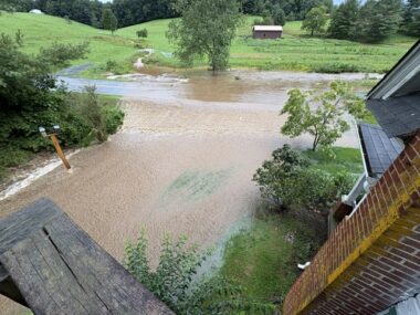 A photo taken from the upper story of a home shows flooding in the road and part of the yard.